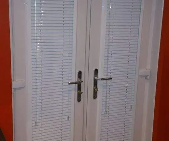 Perfect fit blinds on French doors against a red feature wall