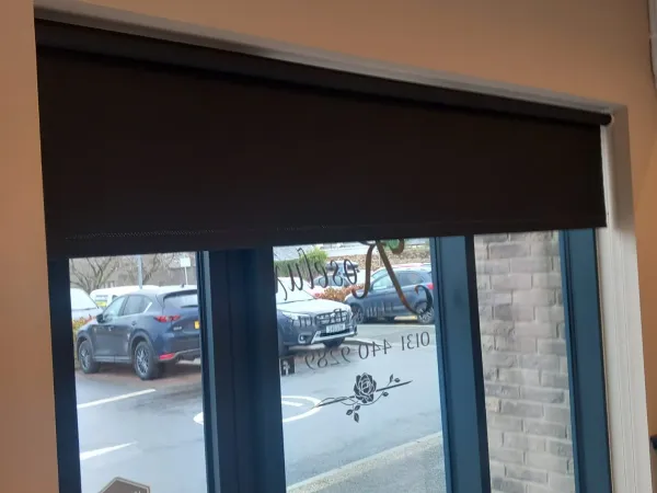 Dark roller blind on a commercial shopfront window in Edinburgh