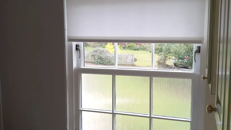 White moisture-resistant roller blind fitted in an Edinburgh bathroom sash window