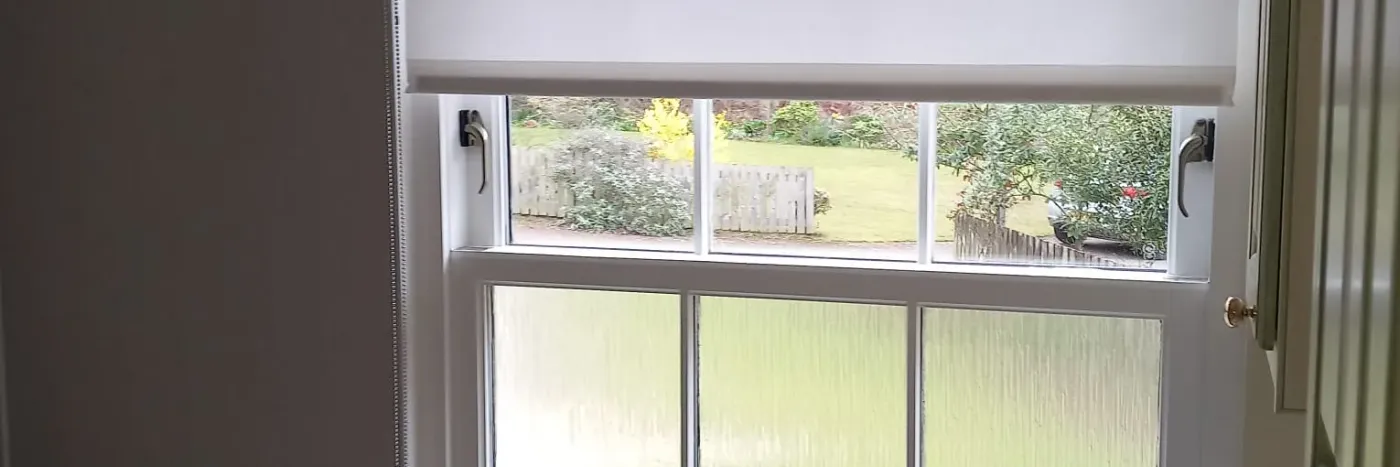 White moisture-resistant roller blind fitted in an Edinburgh bathroom sash window