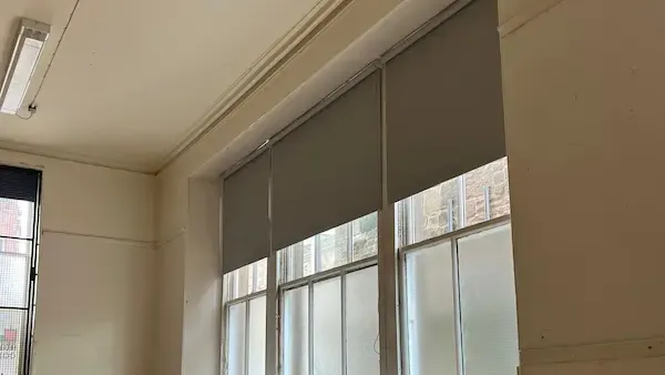 Grey commercial roller blinds fitted in an Edinburgh office building