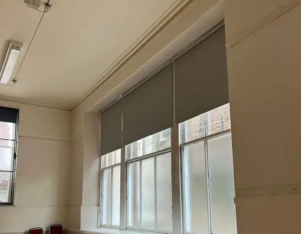 Grey commercial roller blinds fitted in an Edinburgh office building