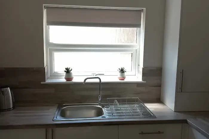 Roller blind fitted above a kitchen sink window