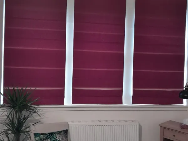 Burgundy roman blinds in a bay window, showcasing the quality of Summerside Blinds products