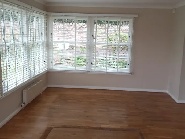 White venetian blinds on a corner bay window