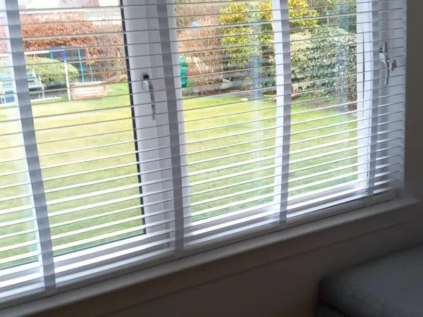 White venetian blinds in a living room window