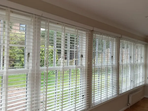 White venetian blinds manufactured and fitted by Summerside Blinds in a bright sunroom